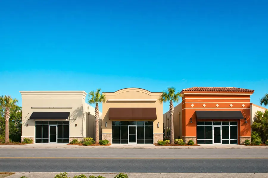 Three similar small commercial buildings side by side on one street