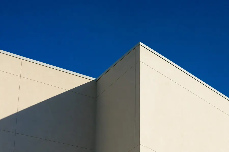 Modern building corner with a sharp diagonal shadow